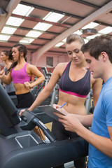 Gym Instructor helping woman