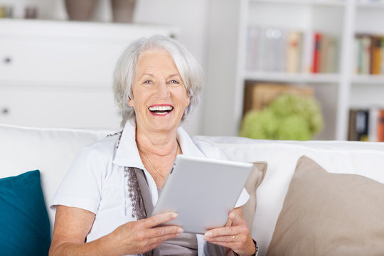 lachende ältere dame mit tablet-pc