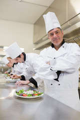 Happy chef with others preparing salads