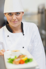 Smiling chef behind dinner plate