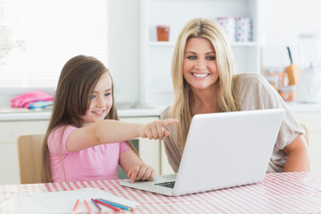 Fototapeta na wymiar Córka wskazując na laptopa z matką