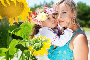 mother with her daughter, summer time with sunflowers