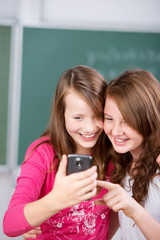 mädchen in der schule schauen auf ihr handy