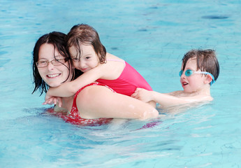 Fototapeta na wymiar Happy family playing in a swimming pool.