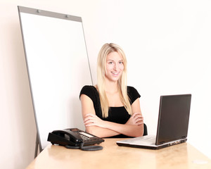 Frau im Büro mit Flipchart verschränkt die Arme