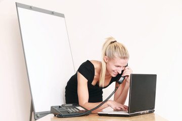 Frau im Büro mit Flipchart telefoniert