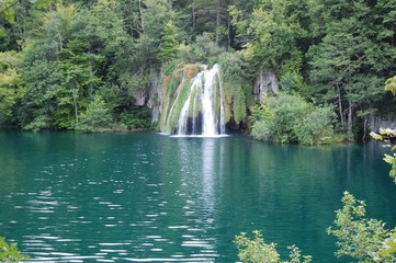 Waterfall pouring into a clear lake