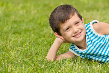 Joyful little boy on the grass