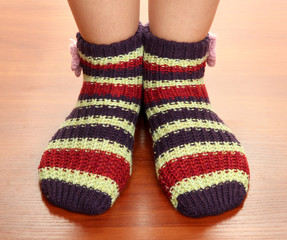 Legs female in striped socks on laminate floor