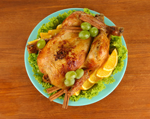 whole roasted chicken with lettuce, grapes, oranges and spices