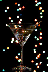 Martini glass and olives on dark bright background
