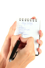 woman's hand holding a notebook with a shopping list close-up