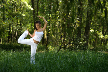 Naklejka na ściany i meble girl practising yoga in nature