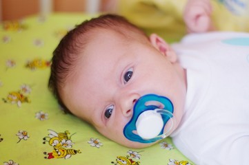 The small child sucks a baby's dummy