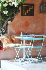 The colorful chairs and tables of the street cafe wait for the visitors