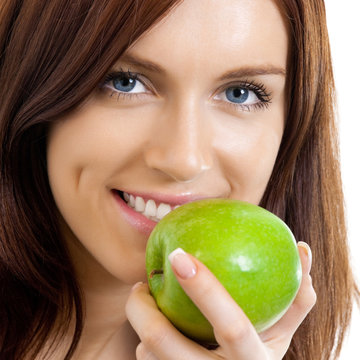 Cheerful woman eating apple, over white