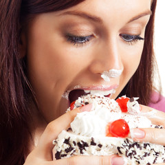 Cheerful woman eating pie, over white