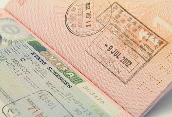 Close up shot of Schengen visa and Hong Kong visa in a passport
