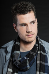 Handsome man dark winter fashion. Studio shot. Wearing scarf.
