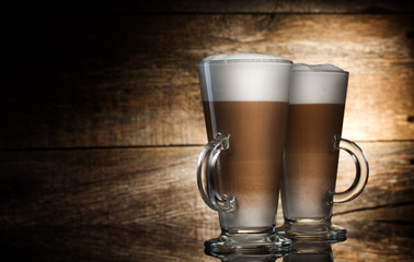 Fragrant coffee latte in glass cups on wooden  background