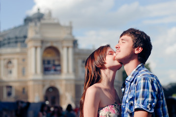 Young happy couple embracing and kissing in city