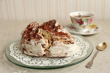 Grande meringue francaise avec une tasse de thé.