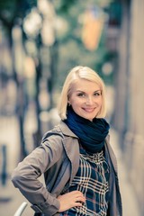 Obraz na płótnie Canvas Beautiful smiling blond woman wearing blue scarf outdoors
