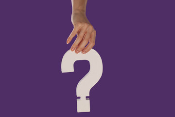 Female hand holding up a question mark from the top
