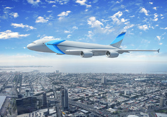Fototapeta na wymiar Biały samolot pasażerski latający nad miastem
