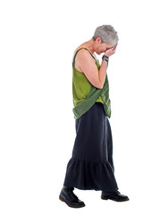 Sad older woman stands in loose flowing long dress