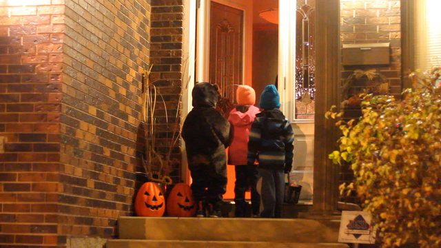 Three children  in Halloween costumes trick or treating