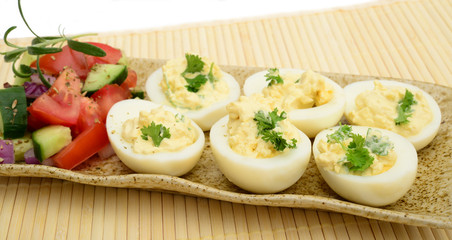 Deviled eggs with tomato, cucumber, onions and herbs