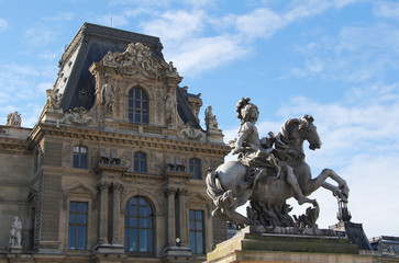 Fototapeta na wymiar Louis XIV statue with Louvre palace