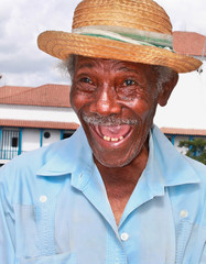Old sympathetic cuban man with straw hat make a funny face, Cuba