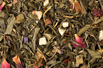 aromatic green dry tea with fruits and petals, close up