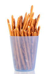 Tasty crispy sticks in purple plastic cup isolated on white