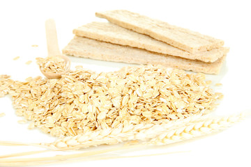 Oat flakes in wooden spoon with spikelets and oat biscuits