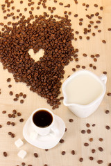 A cup of strong coffee and sweet cream on wooden table close-up
