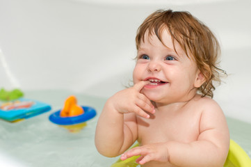 Portrait of cheery cute baby girl in a bath