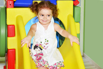 bambina in ludoteca su scivolo