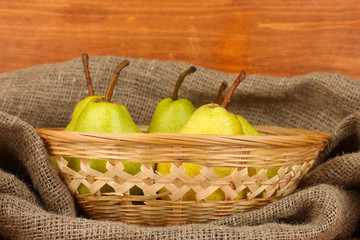 Ripe pears in sack on wooden background close-up