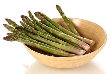 Fresh asparagus in wooden bowl isolated on white.