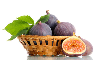 Ripe sweet figs with leaves in basket isolated on white