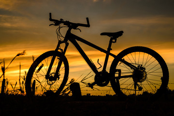 Naklejka na ściany i meble Bicycle silhouette on a sunset