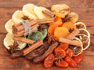 Dried fruits with cinnamon and anise stars on wooden background