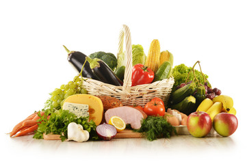 Composition with groceries in wicker basket on kitchen table