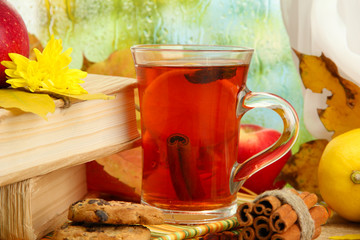 cup of hot tea and autumn leaves, on wooden table