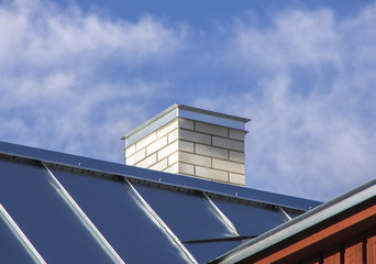 Fototapeta na wymiar Nowy dach metalowy z białym kominem