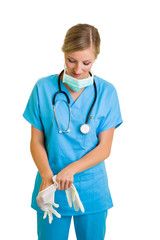 Woman in doctor uniform wearing latex gloves