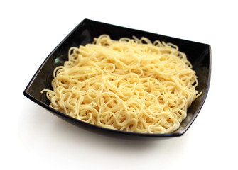 Boiled spaghetti pasta in black bowl